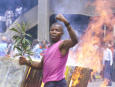 A student taunts riot police after lighting a road barricade , in Nairobi in June, 2002. Photo by George Mulala